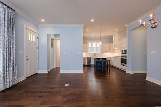 311 Parker St, North Little Rock, AR 72114 - unfurnished living room with crown molding, a sink, baseboards, a chandelier, and dark wood-style floors