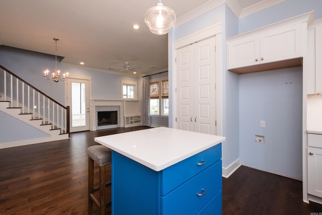 311 Parker St, North Little Rock, AR 72114 - kitchen with ornamental molding, blue cabinets, white cabinets, light countertops, and decorative light fixtures