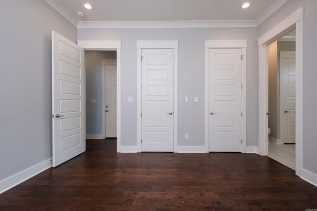 311 Parker St, North Little Rock, AR 72114 - unfurnished bedroom with ornamental molding, dark wood finished floors, recessed lighting, baseboards, and two closets