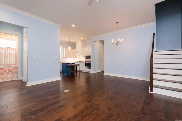 311 Parker St, North Little Rock, AR 72114 - unfurnished living room featuring ornamental molding, a chandelier, baseboards, dark wood-type flooring, and a ceiling fan