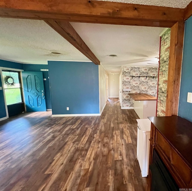470 Lr 28, Foreman, AR 71836 - unfurnished living room with a fireplace, dark wood-style flooring, a textured ceiling, beamed ceiling, and baseboards