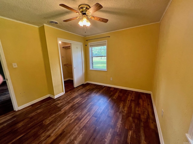 470 Lr 28, Foreman, AR 71836 - unfurnished bedroom featuring a textured ceiling, dark wood finished floors, baseboards, a closet, and crown molding