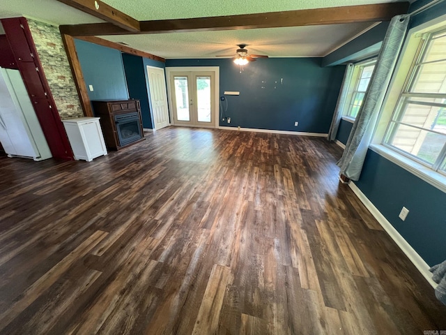470 Lr 28, Foreman, AR 71836 - unfurnished living room featuring a fireplace, a ceiling fan, dark wood-type flooring, beam ceiling, and baseboards
