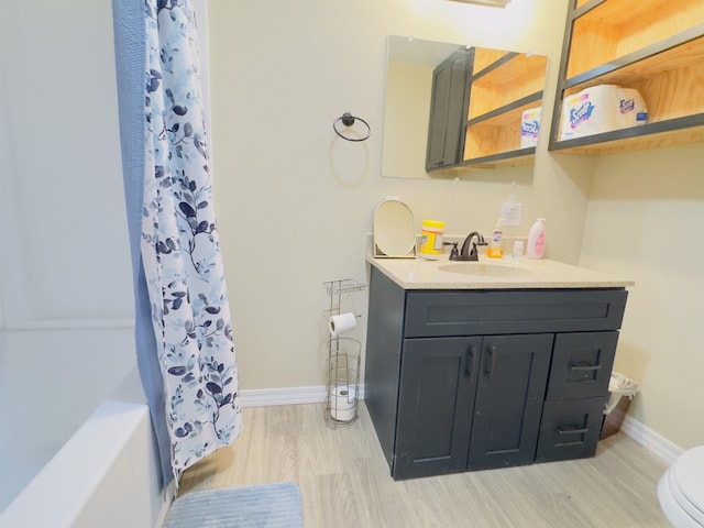 9689 W Ar 56th Hwy, Wideman, AR 72585 - bathroom featuring vanity, baseboards, toilet, wood finished floors, and shower / bathtub combination with curtain
