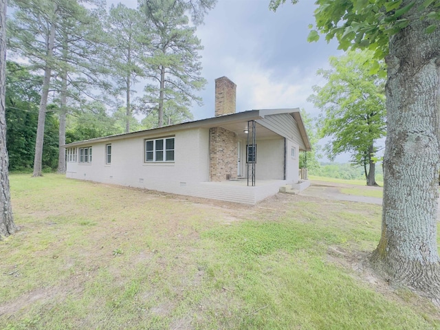 9689 W Ar 56th Hwy, Wideman, AR 72585 - view of side of property featuring a chimney, a porch, brick siding, a yard, and crawl space