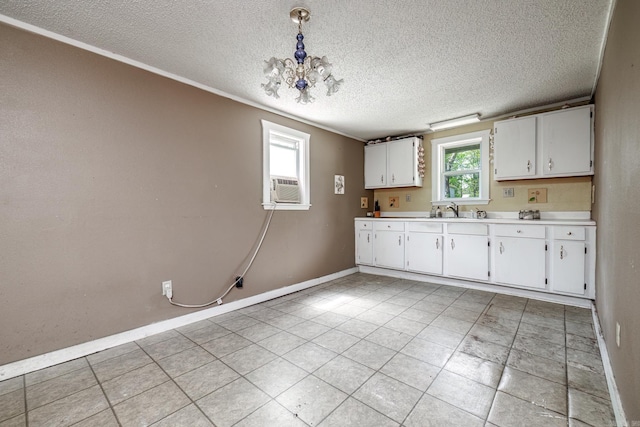 313 W Miller St, Gurdon, AR 71743 - kitchen with white cabinets, baseboards, a textured ceiling, light countertops, and a sink