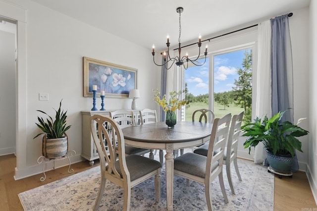 10584 Gunter Loop, Benton, AR 72019 - dining area featuring a chandelier, light wood-style floors, and baseboards