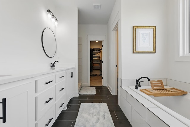 10584 Gunter Loop, Benton, AR 72019 - bathroom with vanity, a walk in closet, tile patterned flooring, and tiled tub
