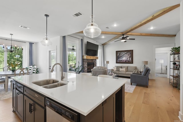 10584 Gunter Loop, Benton, AR 72019 - kitchen featuring a sink, stainless steel dishwasher, a fireplace, light wood-style floors, and light countertops