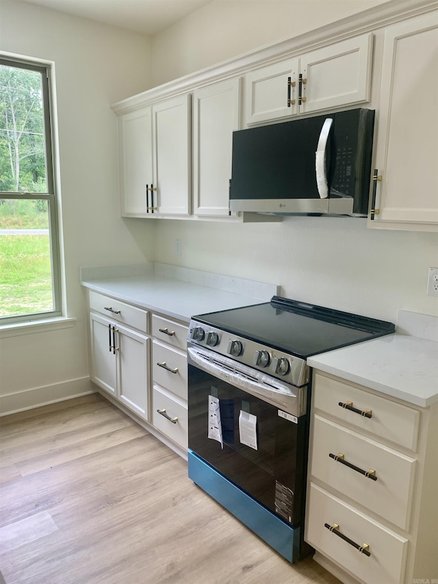 12409 Styles Rd, Bauxite, AR 72011 - kitchen featuring stainless steel electric range, plenty of natural light, light countertops, and light wood-type flooring