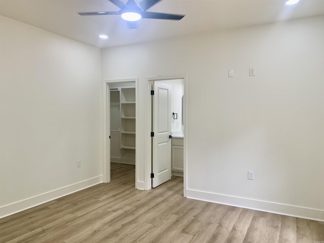 12409 Styles Rd, Bauxite, AR 72011 - unfurnished bedroom featuring a walk in closet, light wood-type flooring, recessed lighting, baseboards, and a closet