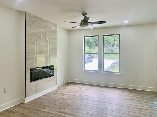 12409 Styles Rd, Bauxite, AR 72011 - empty room featuring a ceiling fan, wood finished floors, a tile fireplace, baseboards, and recessed lighting