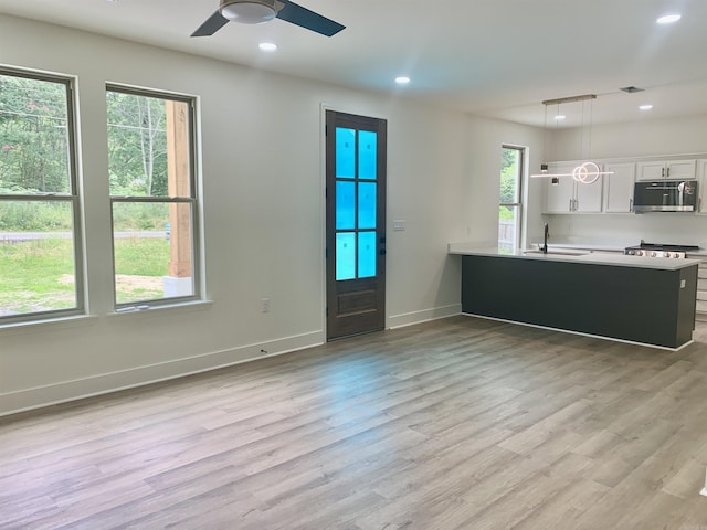 12409 Styles Rd, Bauxite, AR 72011 - kitchen featuring appliances with stainless steel finishes, a sink, white cabinets, light wood-style flooring, and recessed lighting
