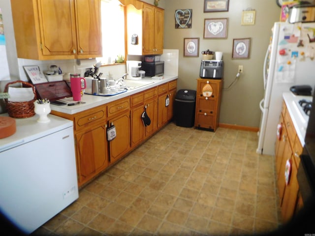 125 N Fairview St, Rector, AR 72461 - kitchen with light countertops, refrigerator, black microwave, brown cabinets, and a sink