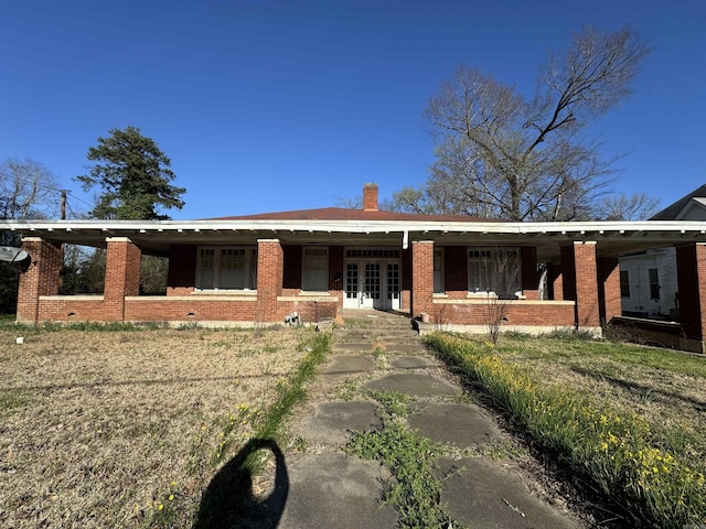 211 California Ave, Camden, AR 71701 - single story home with french doors, brick siding, a chimney, and covered porch