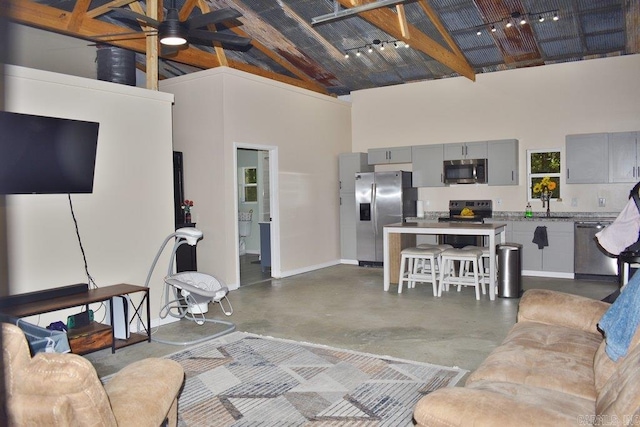 312 Broken Bow Trl, Lonsdale, AR 72087 - living room with high vaulted ceiling, finished concrete flooring, baseboards, beamed ceiling, and a ceiling fan