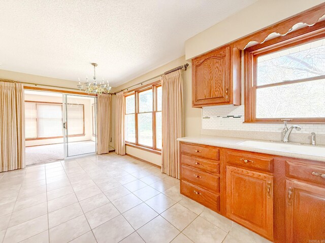 1908 Honeysuckle Dr, Mountain Home, AR 72653 - kitchen with a sink, a chandelier, light countertops, tasteful backsplash, and a textured ceiling