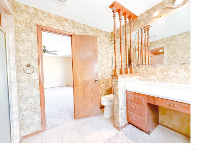 1908 Honeysuckle Dr, Mountain Home, AR 72653 - bathroom featuring vanity, toilet, wallpapered walls, tile patterned floors, and a ceiling fan