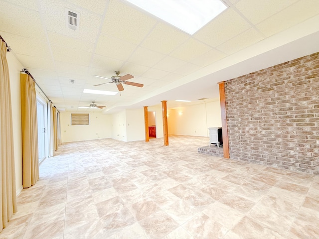 1908 Honeysuckle Dr, Mountain Home, AR 72653 - unfurnished living room with a paneled ceiling, ceiling fan, a wood stove, and brick wall