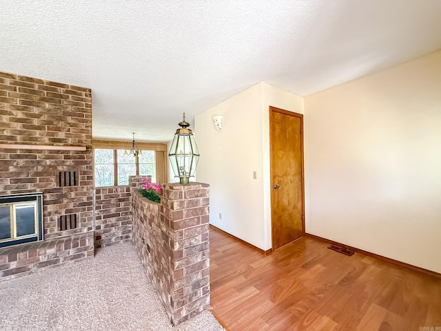 1908 Honeysuckle Dr, Mountain Home, AR 72653 - living area with wood finished floors, a brick fireplace, a textured ceiling, and baseboards