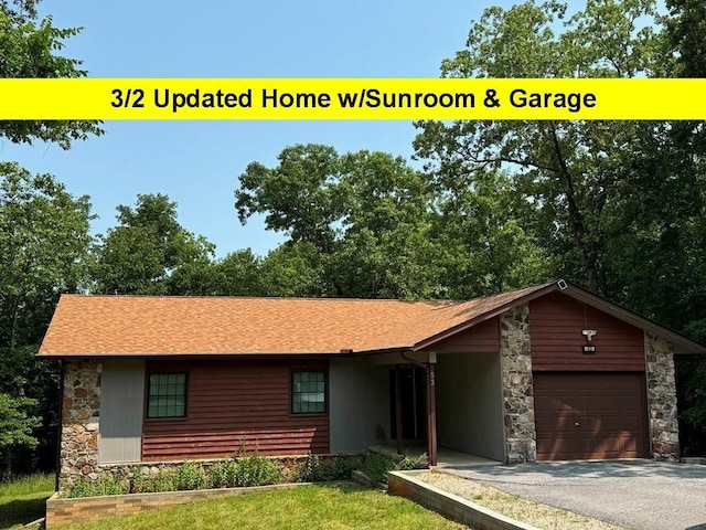 53 Iowa Dr, Cherokee Village, AR 72529 - view of front facade featuring stone siding, an attached garage, and driveway