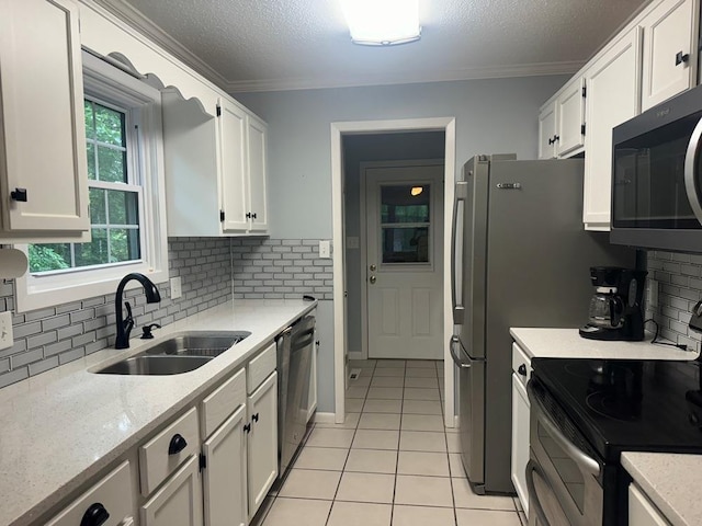 53 Iowa Dr, Cherokee Village, AR 72529 - kitchen with stainless steel appliances, a sink, light tile patterned flooring, white cabinetry, and tasteful backsplash