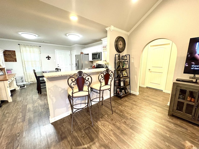 135 Meadow Dr, Beebe, AR 72012 - kitchen featuring stainless steel appliances, white cabinets, ornamental molding, a peninsula, and a kitchen bar