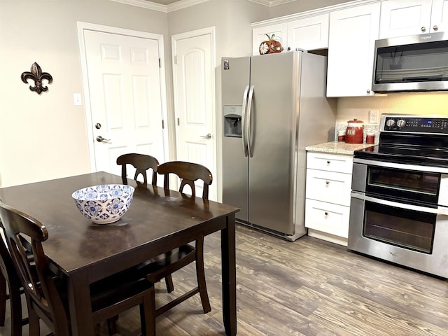 135 Meadow Dr, Beebe, AR 72012 - kitchen featuring appliances with stainless steel finishes, crown molding, white cabinets, and wood finished floors