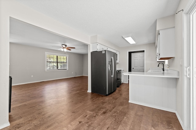 1214 Sammy St, Mountain Home, AR 72653 - kitchen featuring stainless steel appliances, a sink, light countertops, dark wood-style flooring, and a textured ceiling