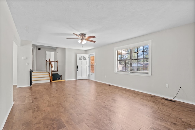 1214 Sammy St, Mountain Home, AR 72653 - unfurnished living room featuring stairs, ceiling fan, wood finished floors, and baseboards