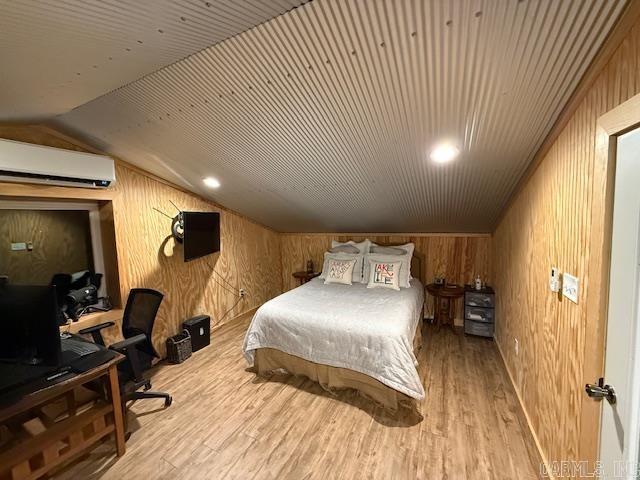 630 Cliffview Dr, Quitman, AR 72131 - bedroom featuring a wall mounted air conditioner, wood finished floors, wooden walls, lofted ceiling, and a desk