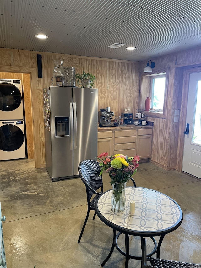 630 Cliffview Dr, Quitman, AR 72131 - kitchen with stainless steel fridge, stacked washer / dryer, finished concrete flooring, and wood walls