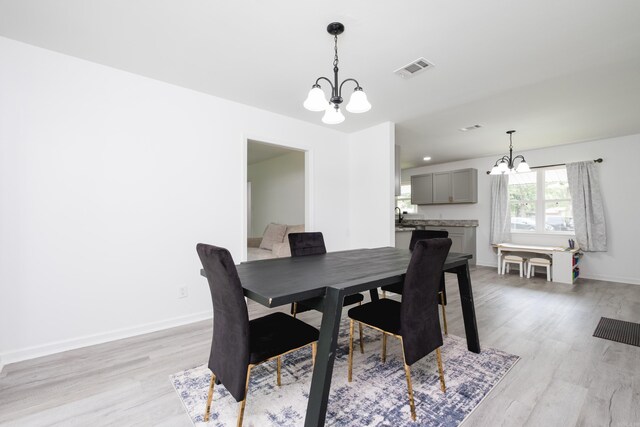 4605 N Cedar, North Little Rock, AR 72116 - dining area featuring a chandelier, light wood-type flooring, and baseboards