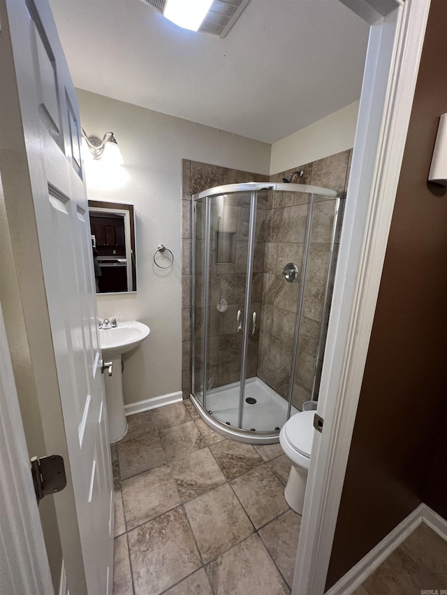 full bath with toilet, baseboards, and a stall shower