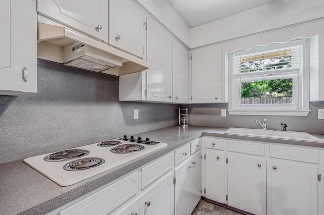 4204 Fox Hill Rd, North Little Rock, AR 72116 - kitchen with white electric stovetop, a sink, white cabinets, and under cabinet range hood
