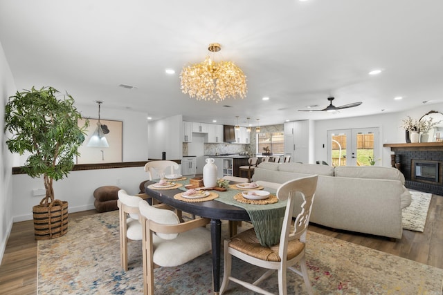 7 Buttermilk Rd, Little Rock, AR 72227 - dining space with wood finished floors, recessed lighting, a chandelier, a glass covered fireplace, and a ceiling fan