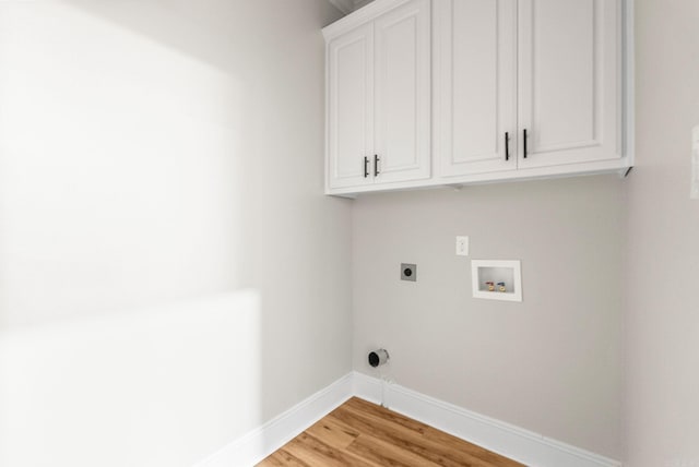 laundry area featuring cabinet space, light wood-type flooring, hookup for an electric dryer, hookup for a washing machine, and baseboards