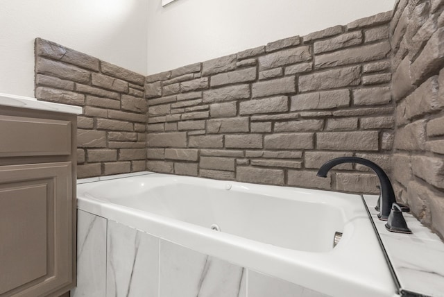 bathroom with a jetted tub and vanity