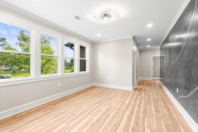 empty room with ornamental molding, light wood finished floors, baseboards, and recessed lighting