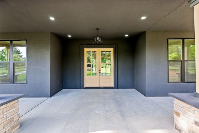 doorway to property featuring french doors, stucco siding, and a patio area