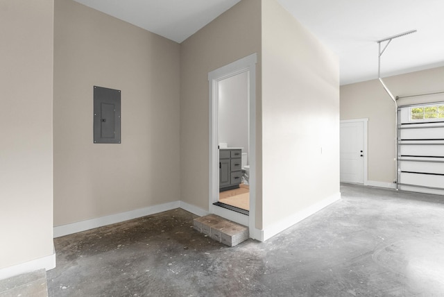 garage featuring electric panel and baseboards