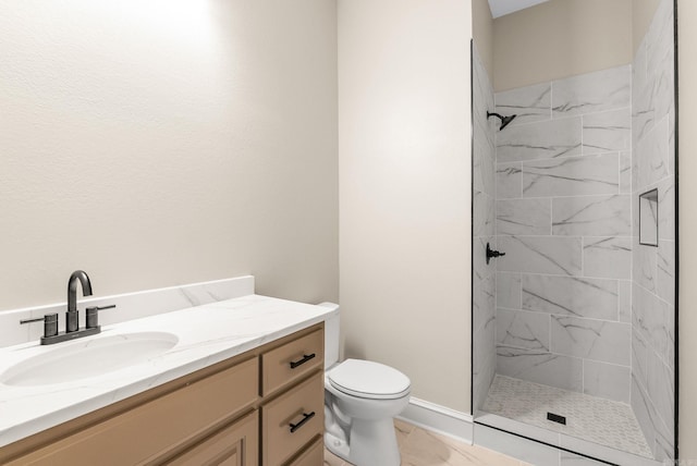 bathroom with vanity, a tile shower, and toilet