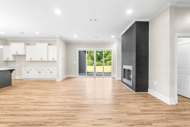 unfurnished living room featuring crown molding, baseboards, light wood-style flooring, recessed lighting, and a fireplace