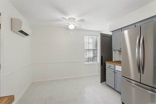 1810 S Pierce St, Little Rock, AR 72204 - kitchen with freestanding refrigerator, butcher block counters, gray cabinetry, and a wall mounted air conditioner