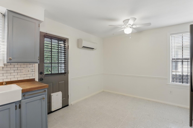 1810 S Pierce St, Little Rock, AR 72204 - kitchen with wood counters, an AC wall unit, gray cabinets, and ceiling fan