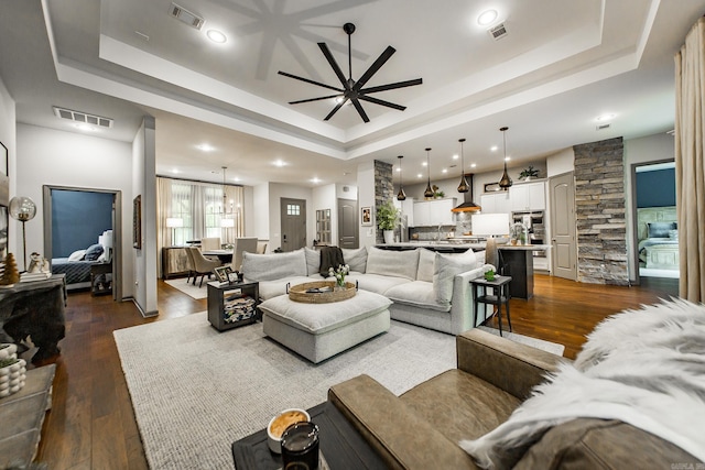 43 Mikes Cir, Heber Springs, AR 72543 - living room with a tray ceiling, ceiling fan, dark wood-style floors, recessed lighting, and a chandelier