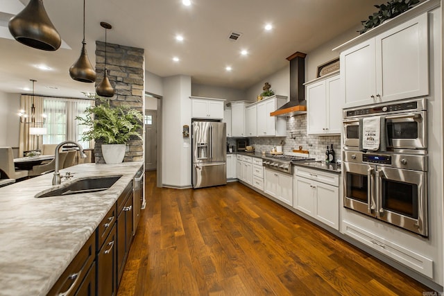 43 Mikes Cir, Heber Springs, AR 72543 - kitchen featuring stainless steel appliances, a sink, wall chimney range hood, backsplash, and dark wood-style floors