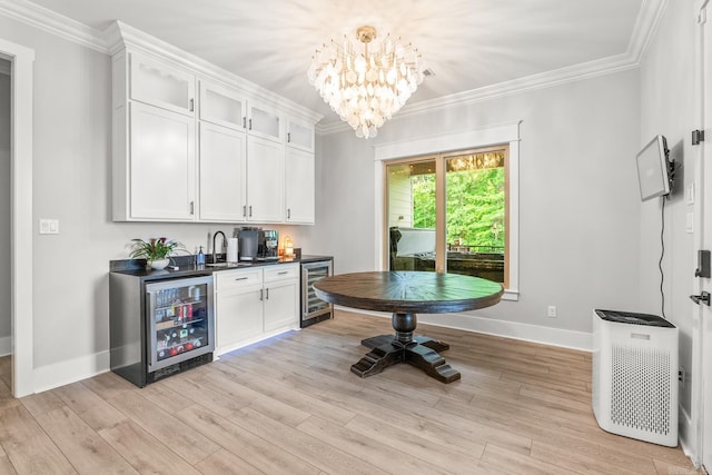 67 Falstone Dr, Little Rock, AR 72223 - indoor wet bar with beverage cooler, baseboards, a chandelier, ornamental molding, and light wood-style floors