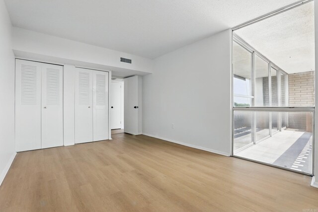 700 E 9th J St, Little Rock, AR 72202 - unfurnished bedroom with wood finished floors, baseboards, and multiple closets