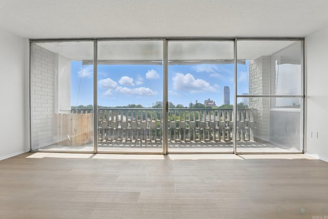 700 E 9th J St, Little Rock, AR 72202 - unfurnished room with floor to ceiling windows, wood finished floors, and baseboards